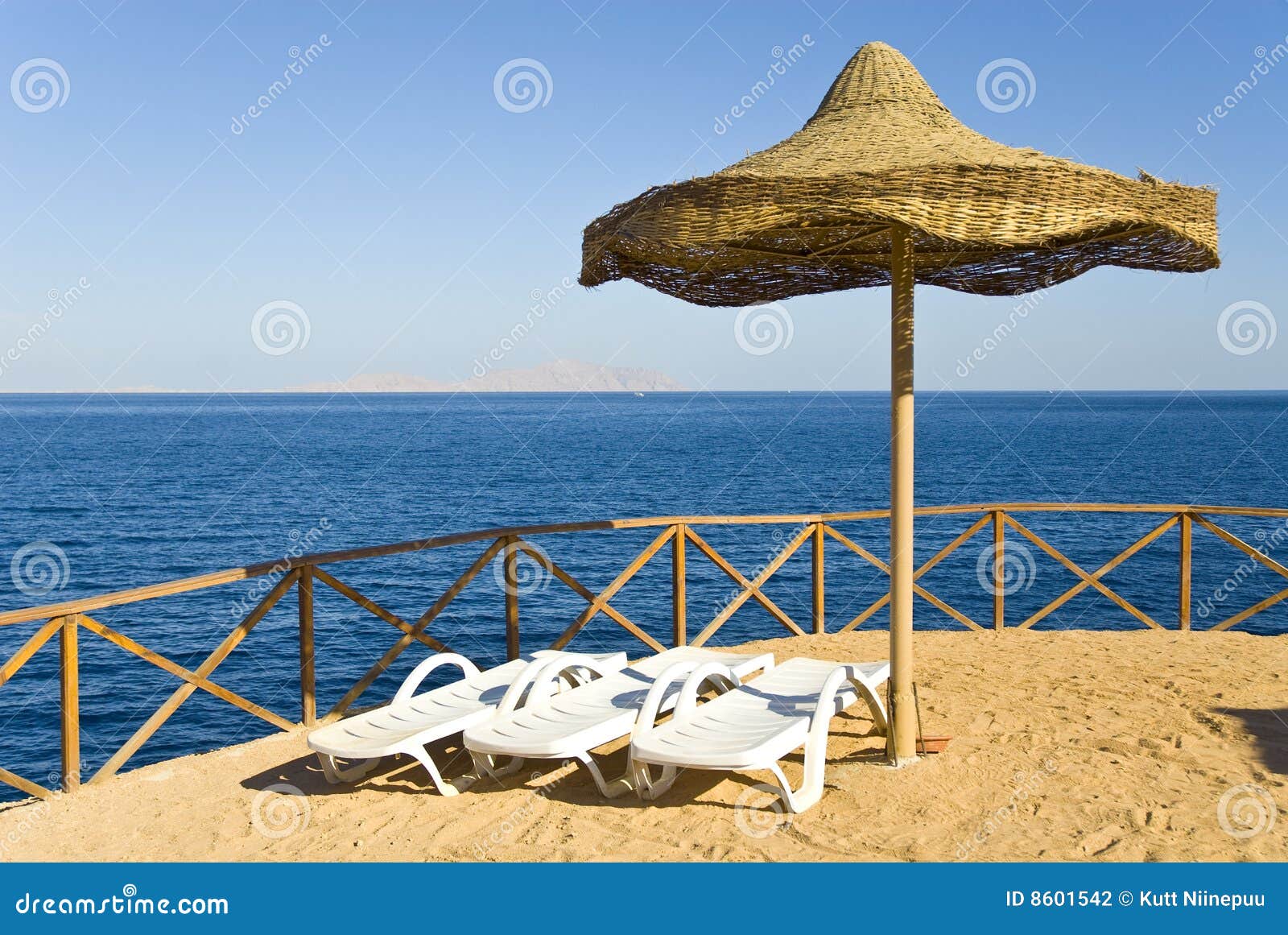 Lounge chairs and umbrella stock photo.
