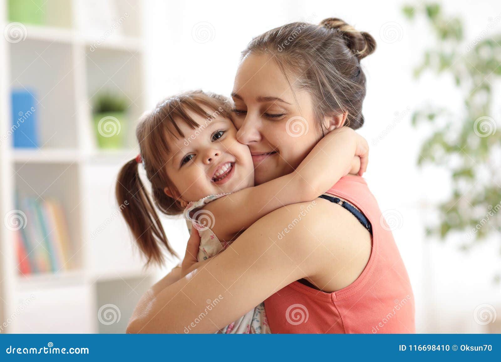 love and family people concept - happy mother and child daughter hugging at home