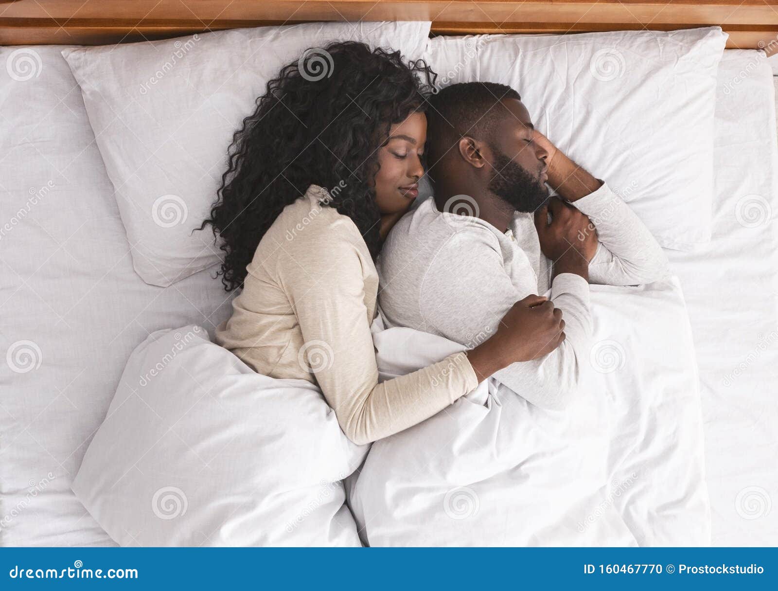 Romantic Black Couple Hugging while Sleeping in Bed Stock Photo