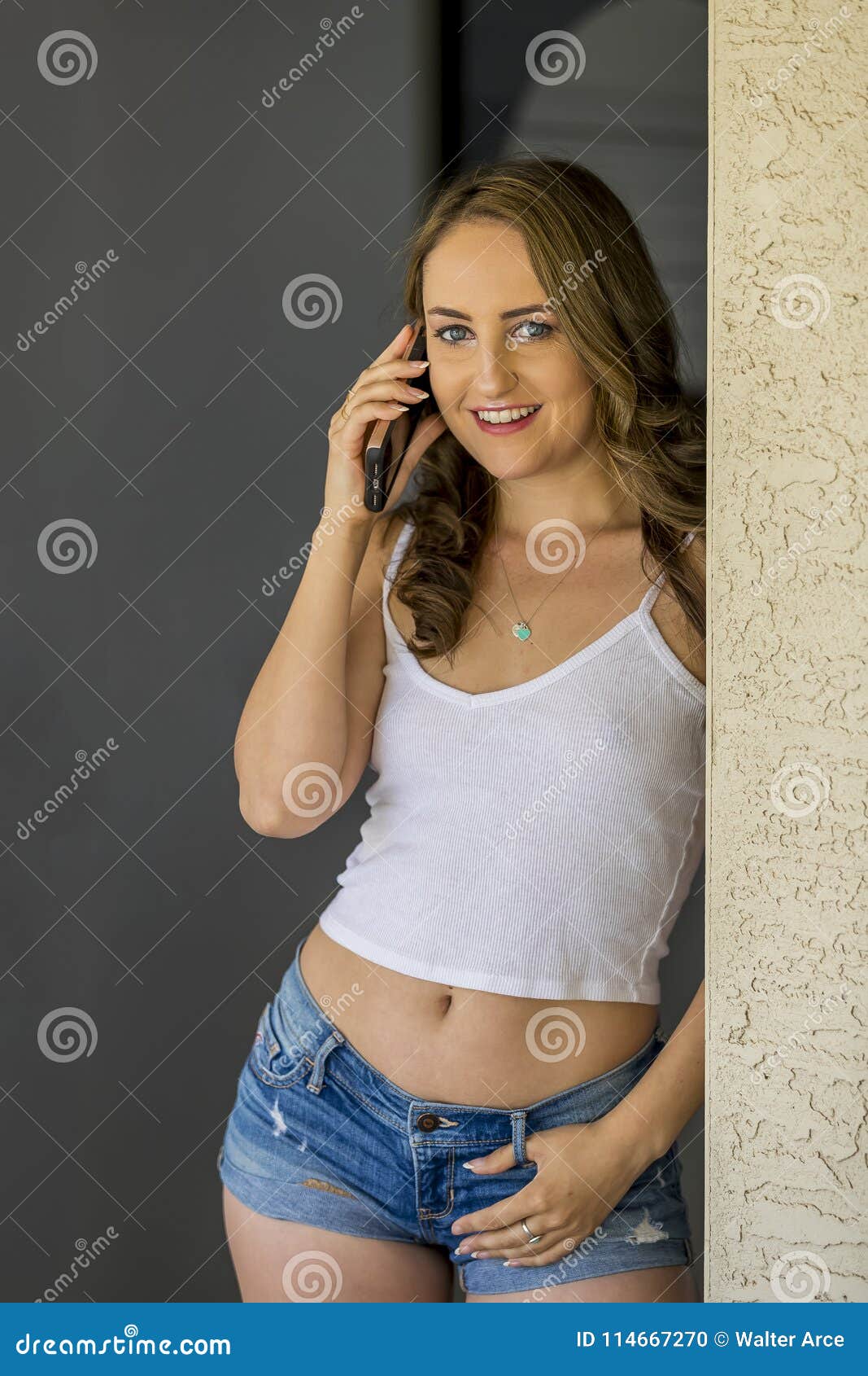 Lovely Brunette Model Posing At Home Receiving News On Her Mobile 