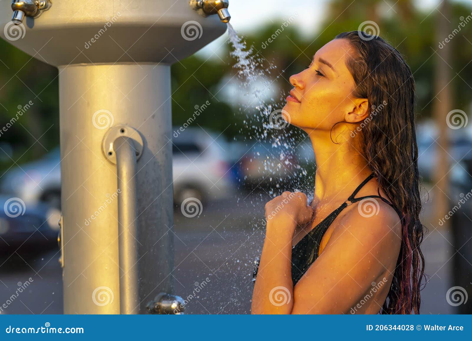 A Lovely Brunette Model Showers Outdoors After Swimming In The Ocean