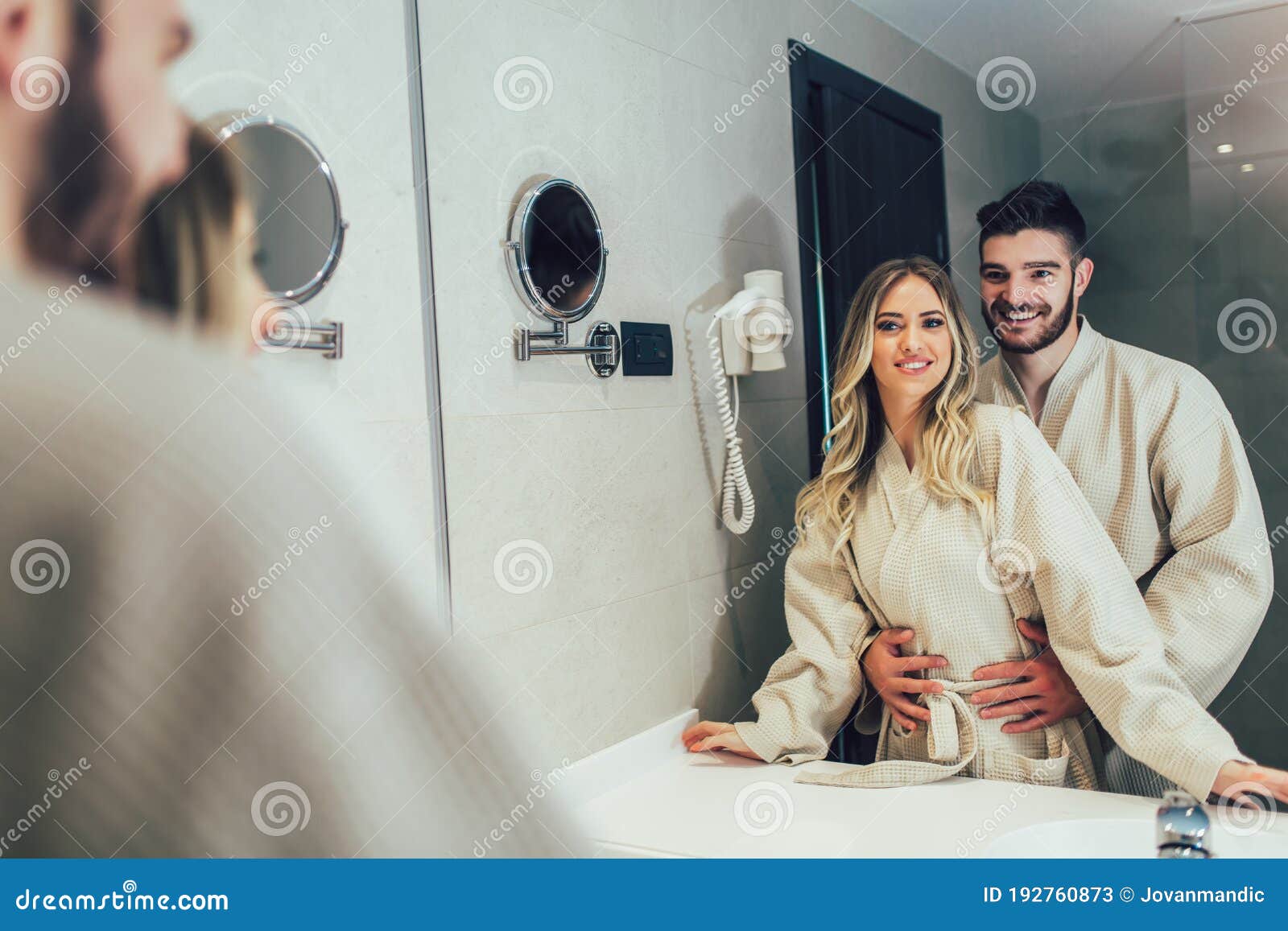 Couple In Front Of The Mirror While Getting Ready In The Bathroom Sto