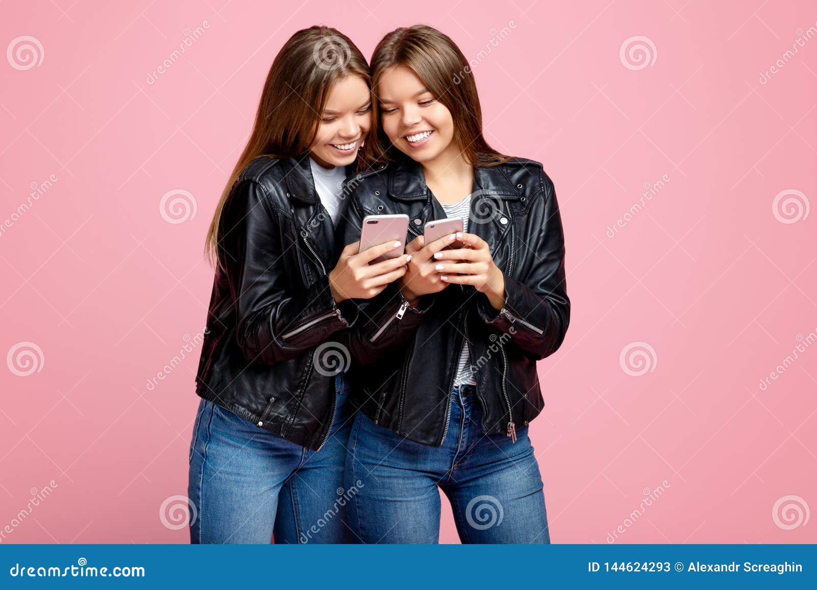 Lovely Two Young Twin Sisters with Bright Smile in Leather Jackets Use ...