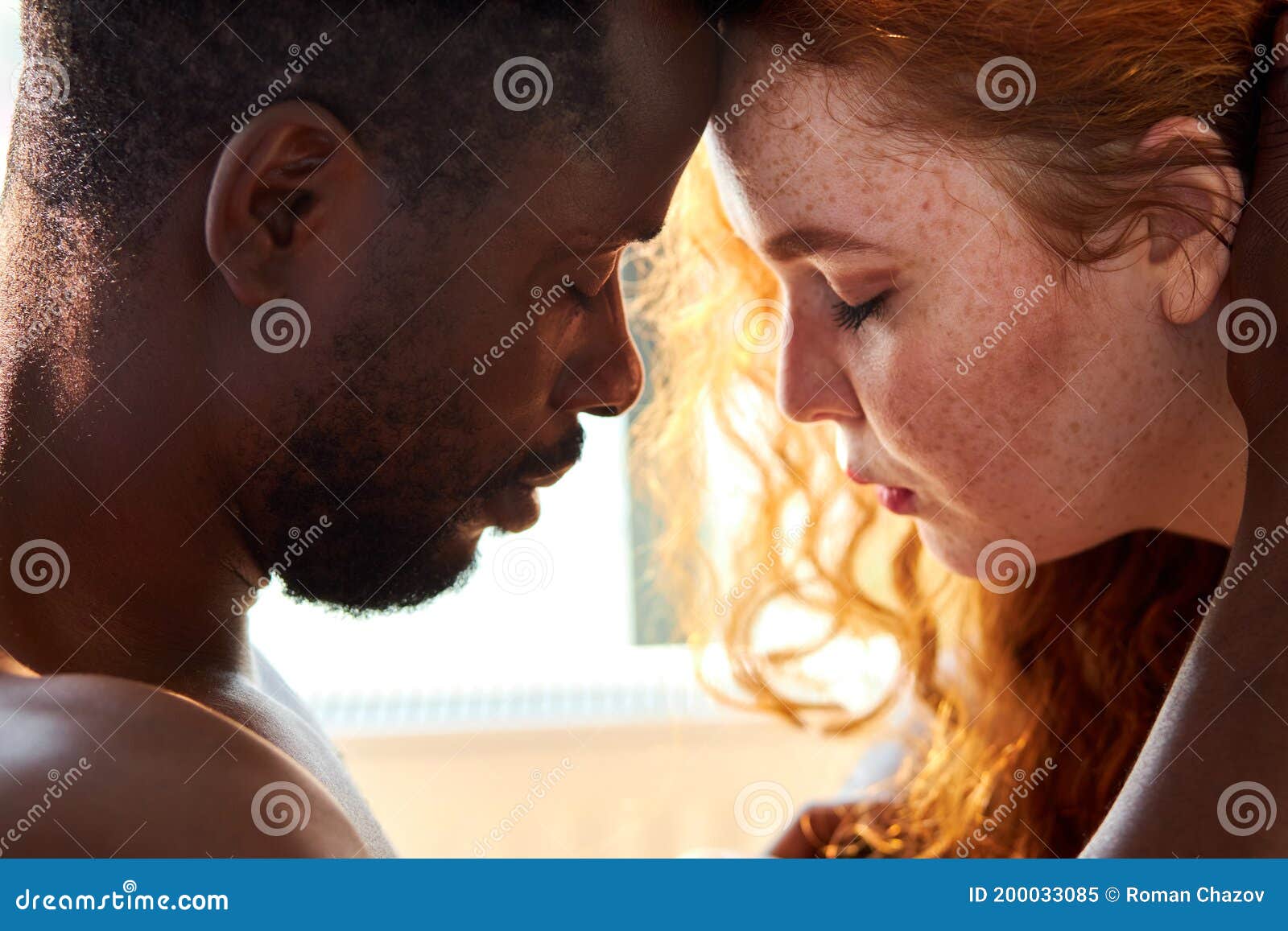 Loving Affectionate Nude Interracial Couple on Bed, Going To Kiss Stock