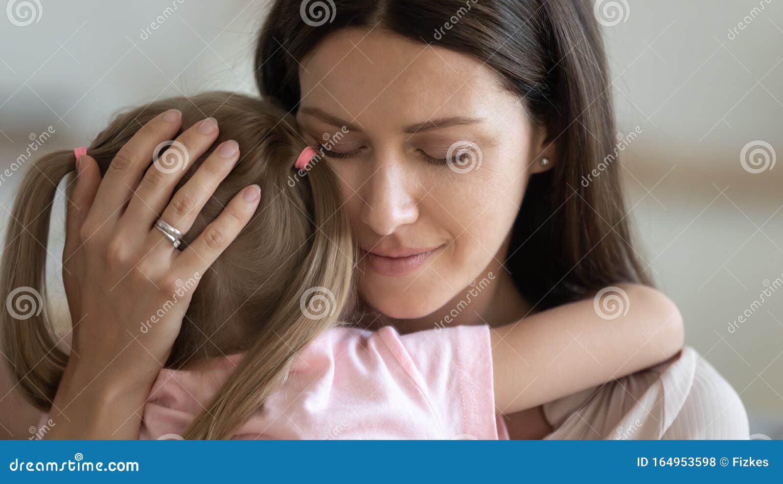 loving foster parent mom hugging little kid daughter giving comfort