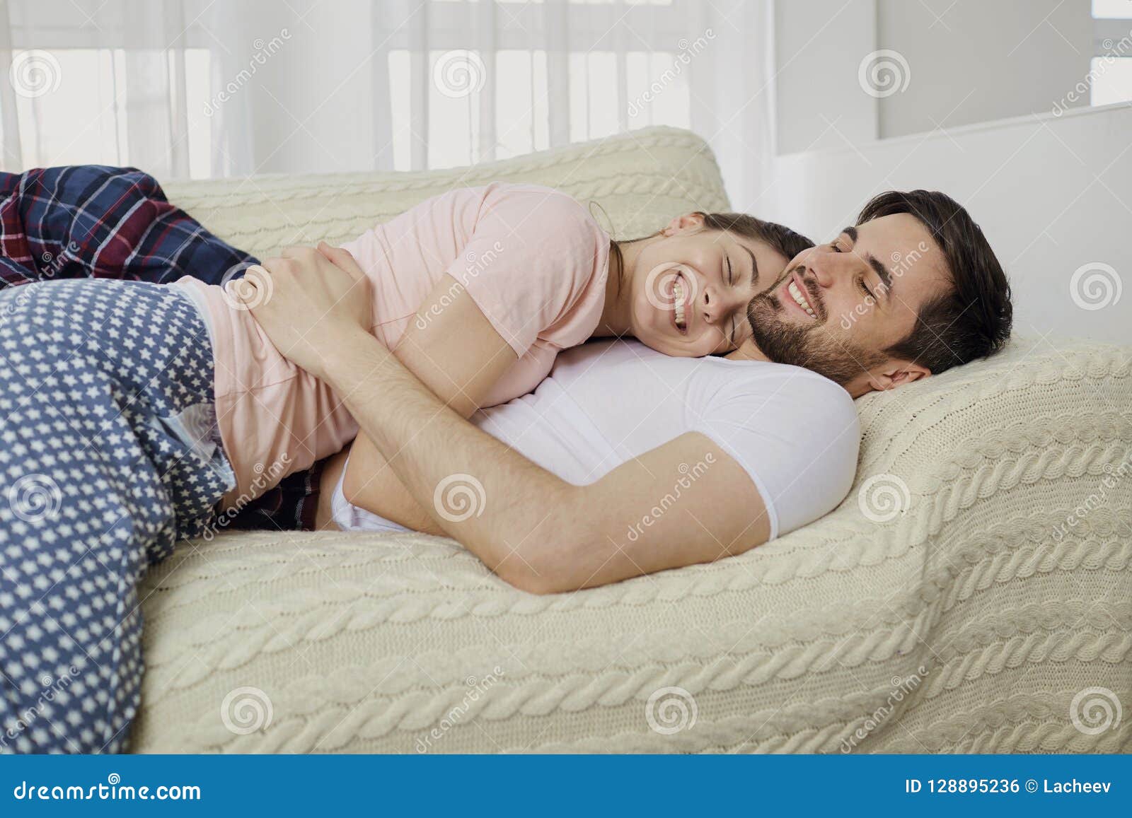 A Loving Couple Hugs Lying on the Bed in the Room. Stock Photo ...