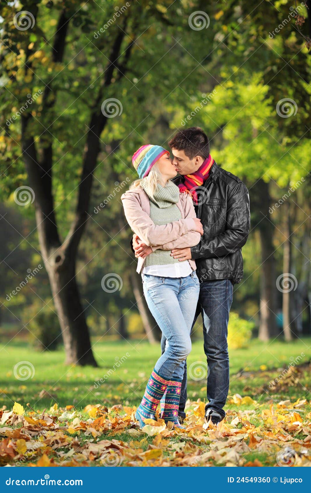 Romantic couple kissing while sitting on chair by railing stock photo