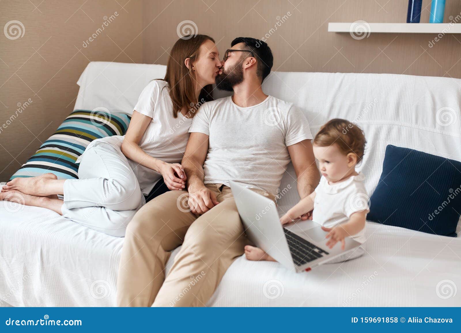 Loving Couple Kissing while Their Baby Watchcing Cartoon on the Laptop  Stock Photo - Image of childhood, computer: 159691858