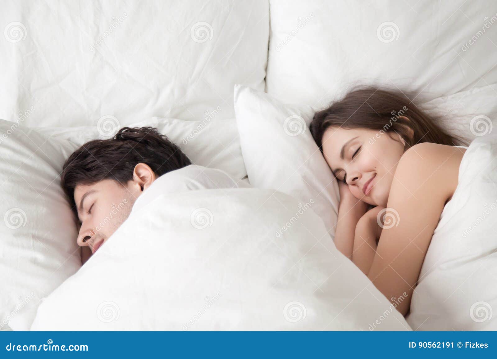 loving couple sleeping peacefully in comfortable bed, falling as