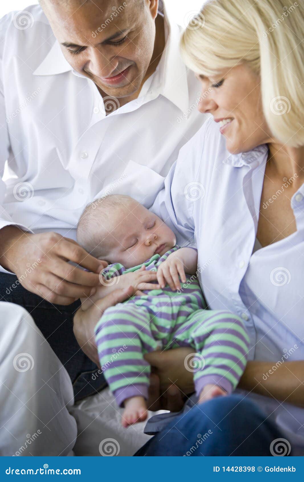 loving parents holding baby sound asleep in arms