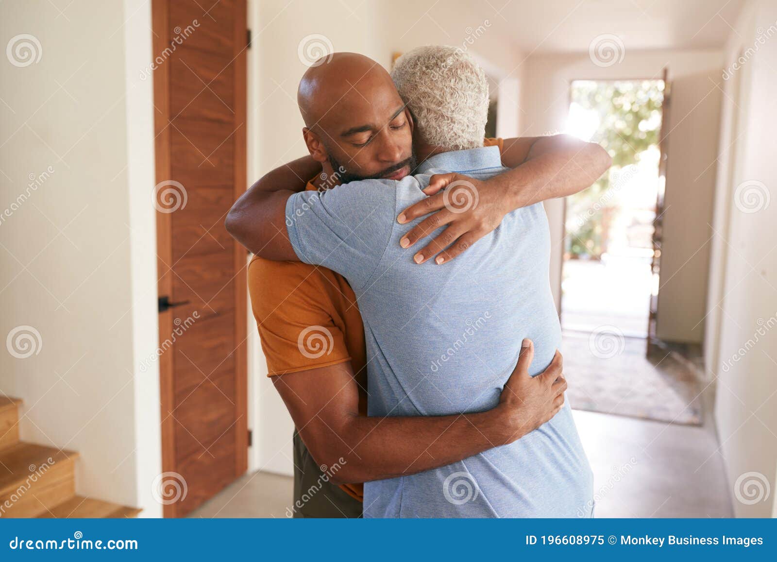 loving senior father hugging adult son indoors at home