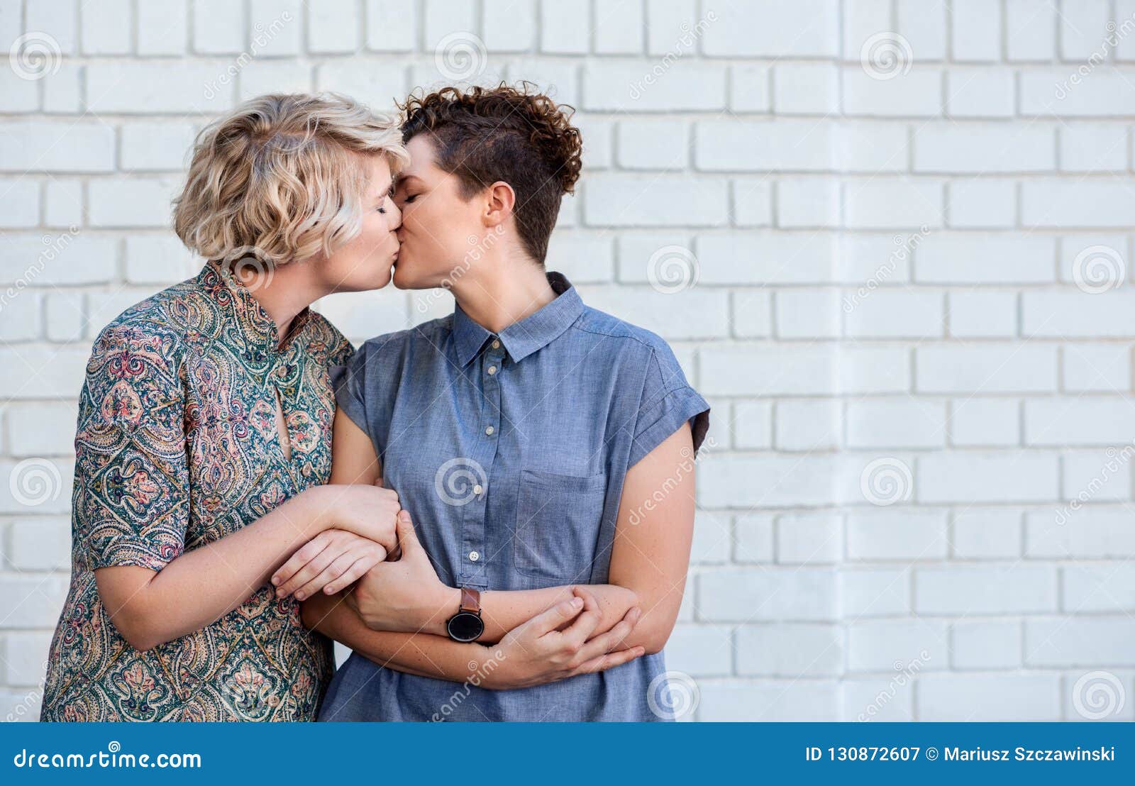 Loving Young Lesbian Couple Standing Outside Sharing a Kiss Stock Image