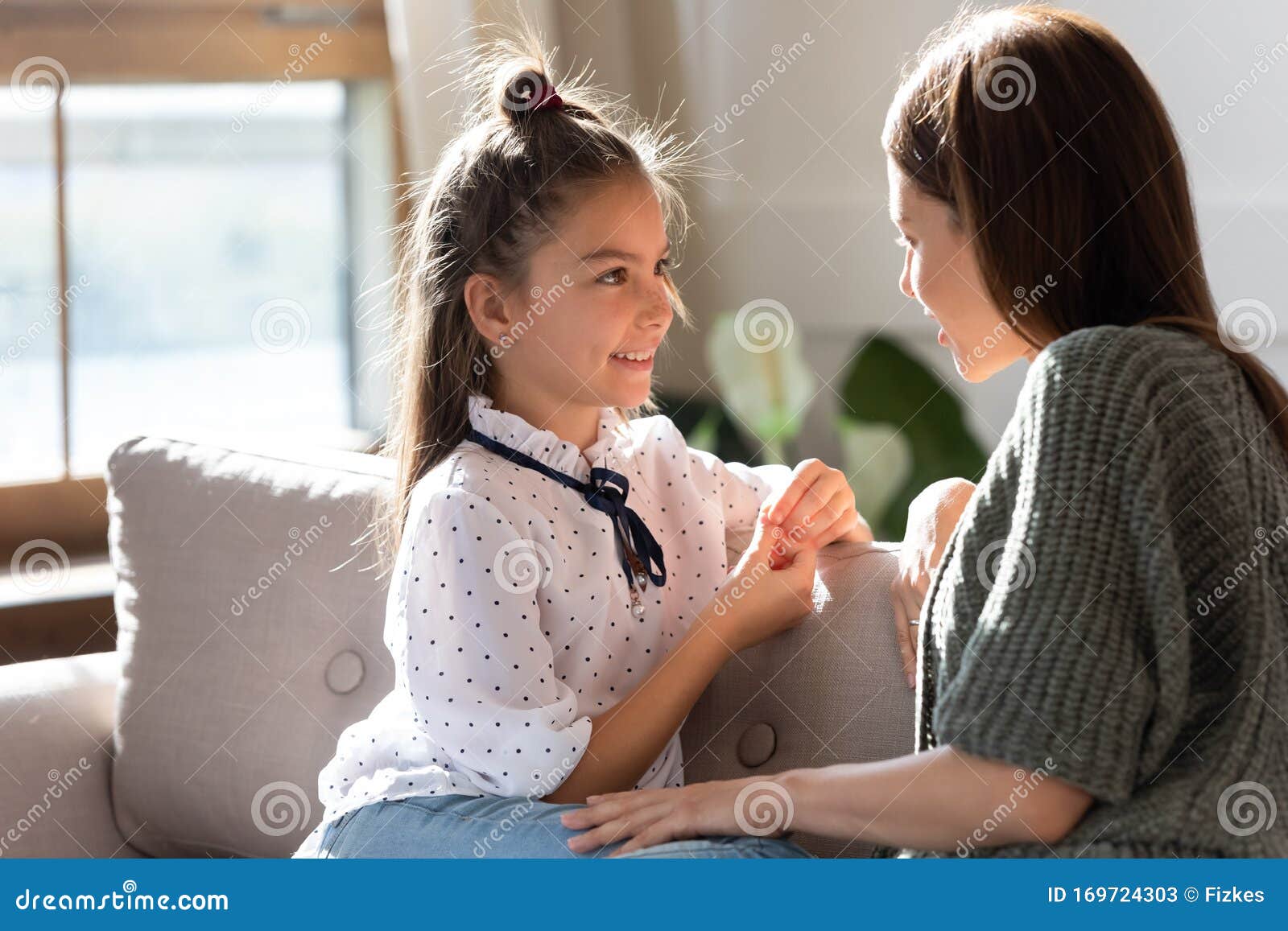 Loving Young Mom And Little Daughter Share Secrets On Couch Stock Image