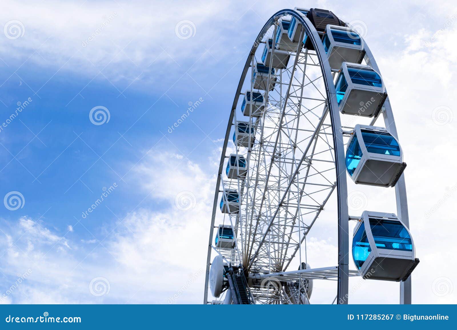 Low Angle View Of A Ferris Wheel In An Amusement Park With A Blue