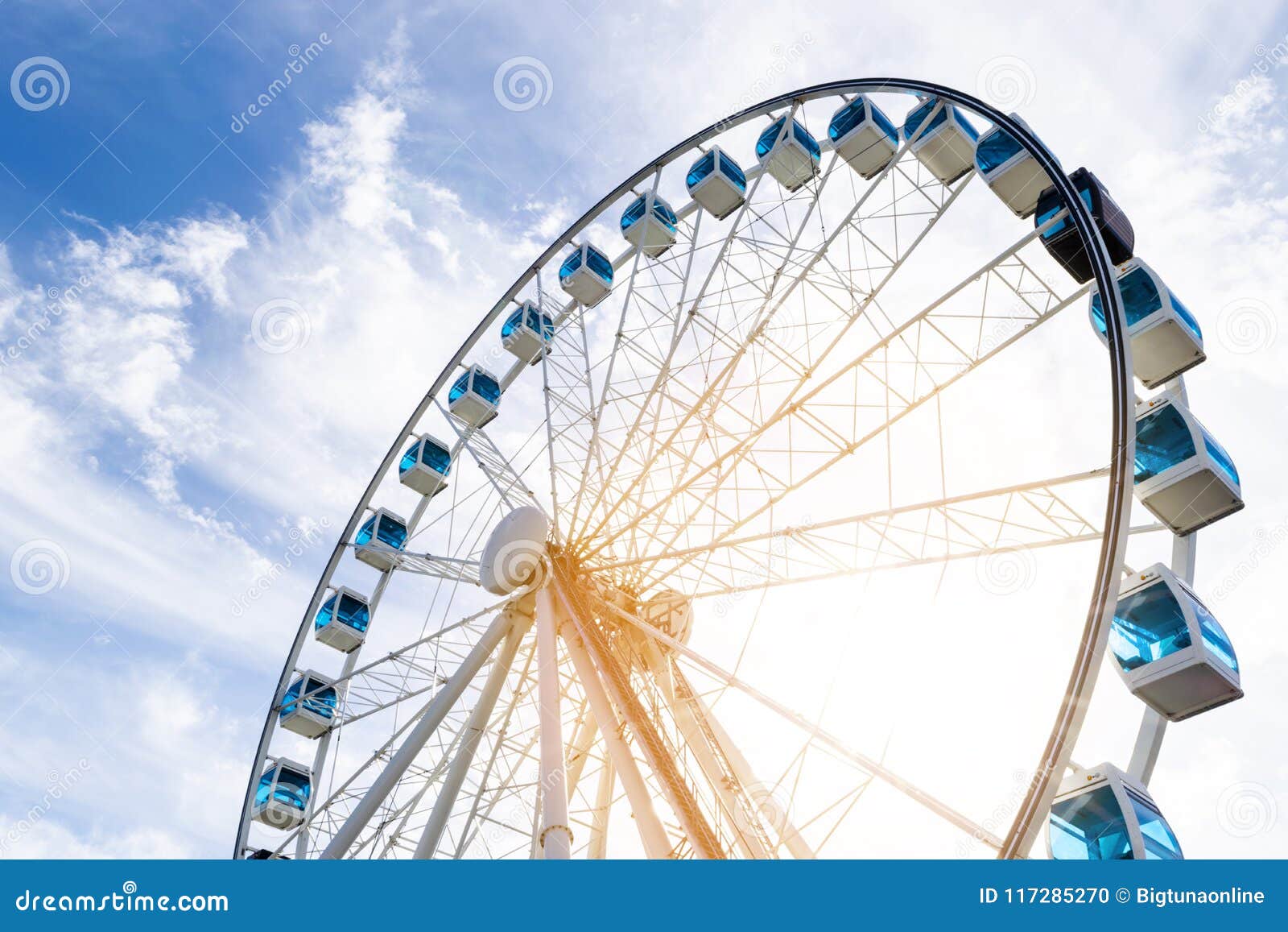 Low Angle View Of A Ferris Wheel In An Amusement Park With A Blue
