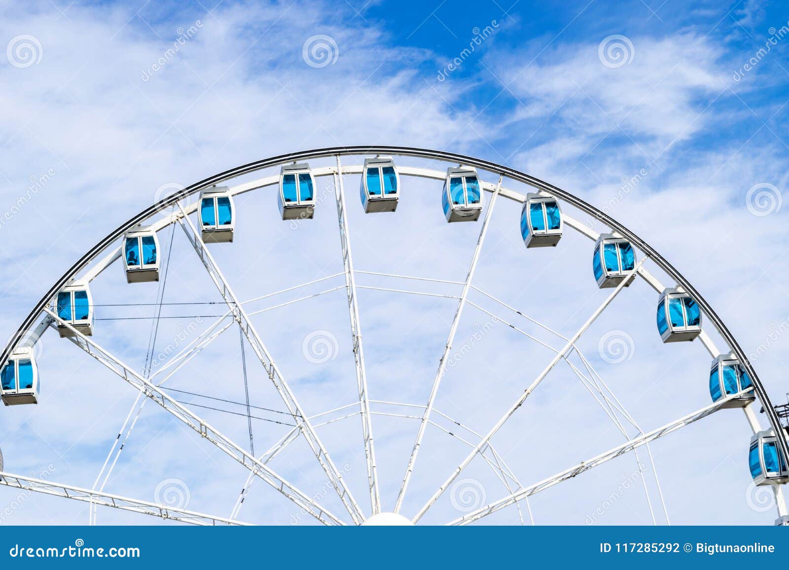 Low Angle View Of A Ferris Wheel In An Amusement Park With A Blue