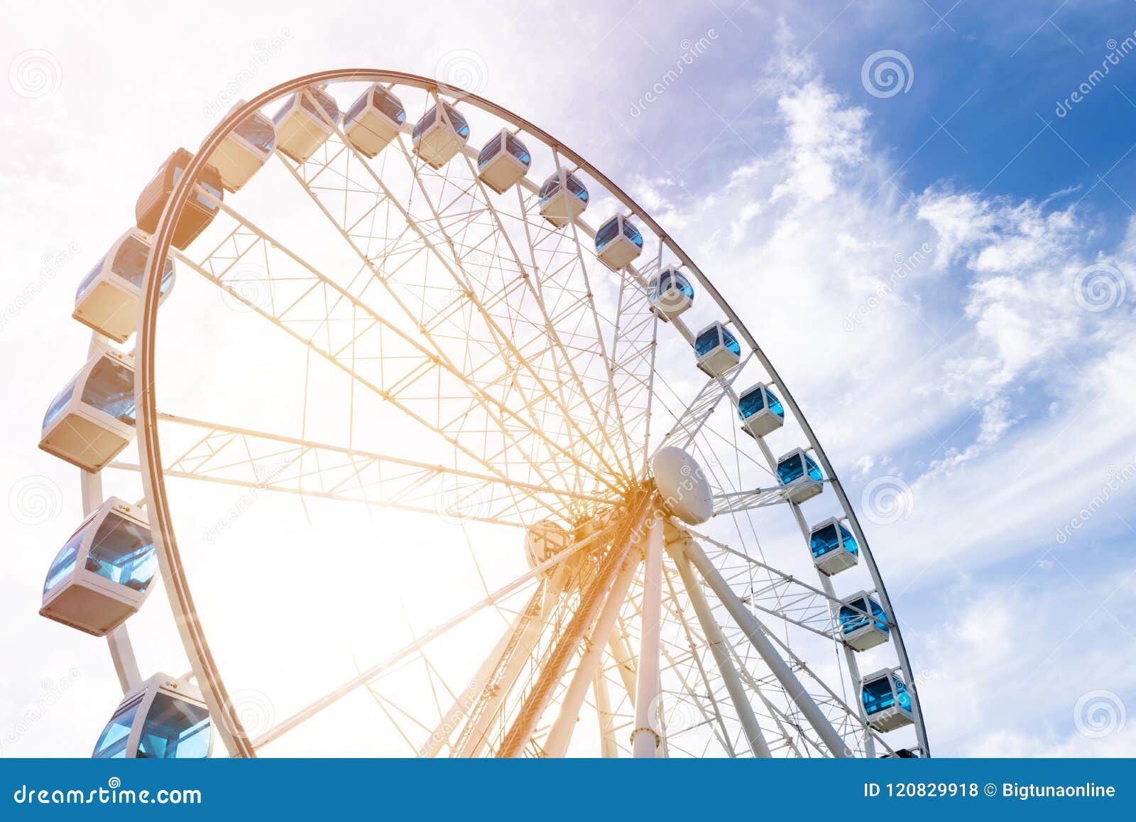 Low Angle View Of A Ferris Wheel In An Amusement Park With A Blue