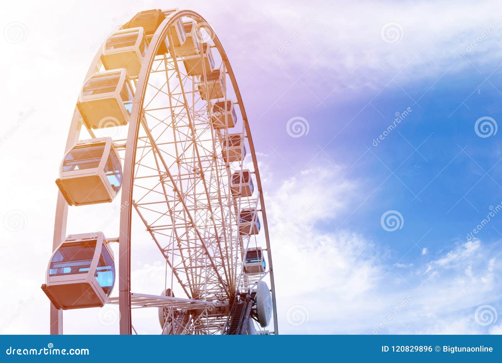 Low Angle View Of A Ferris Wheel In An Amusement Park With A Blue