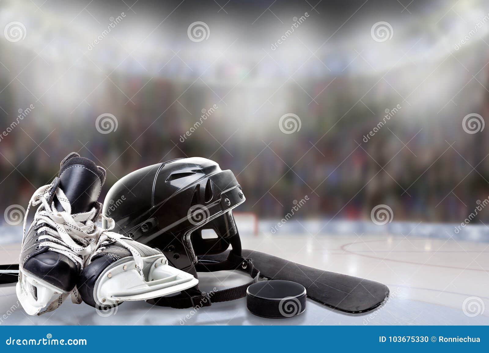 ice hockey helmet, skates, stick and puck in rink