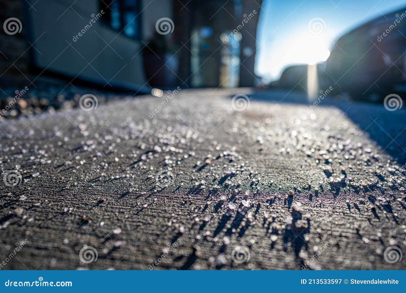 Low Angle View of Salt Spread on Sidewalk To Melt Ice and Snow Stock