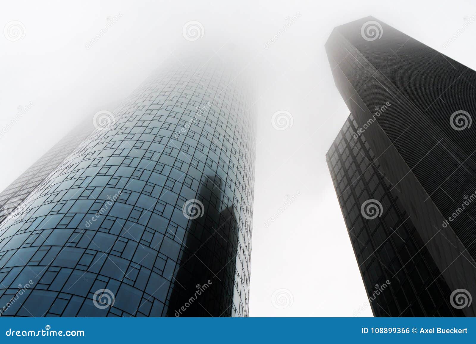 low angle view of two skyscrapers shrouded in fog or mist in the banking district of frankfurt germany