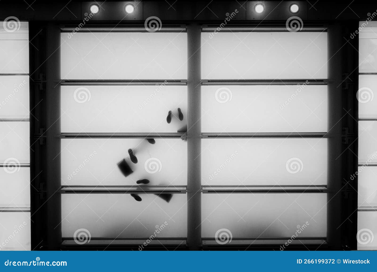 Low Angle View of a White Glass Floor in an Elevator with Silhouettes