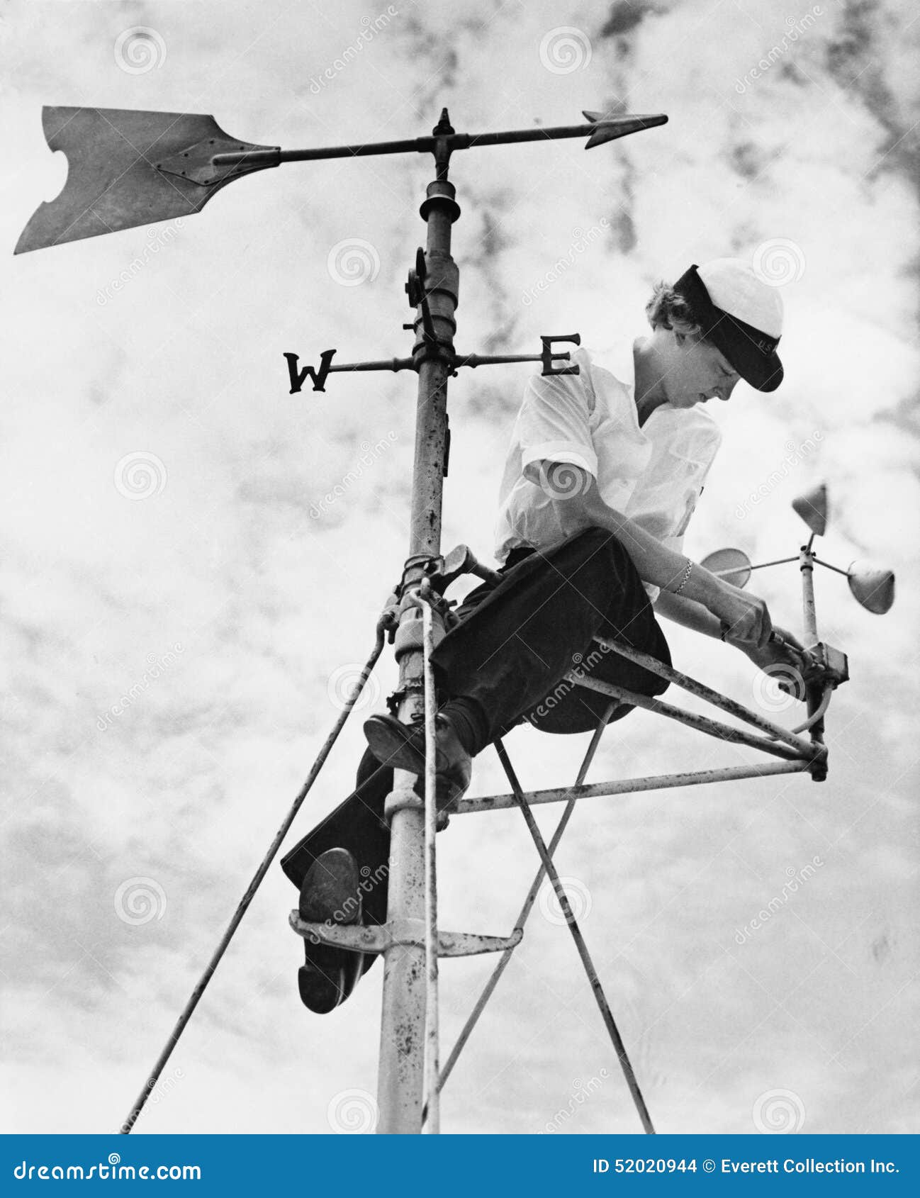 low angle view of a young woman mending a weather vane
