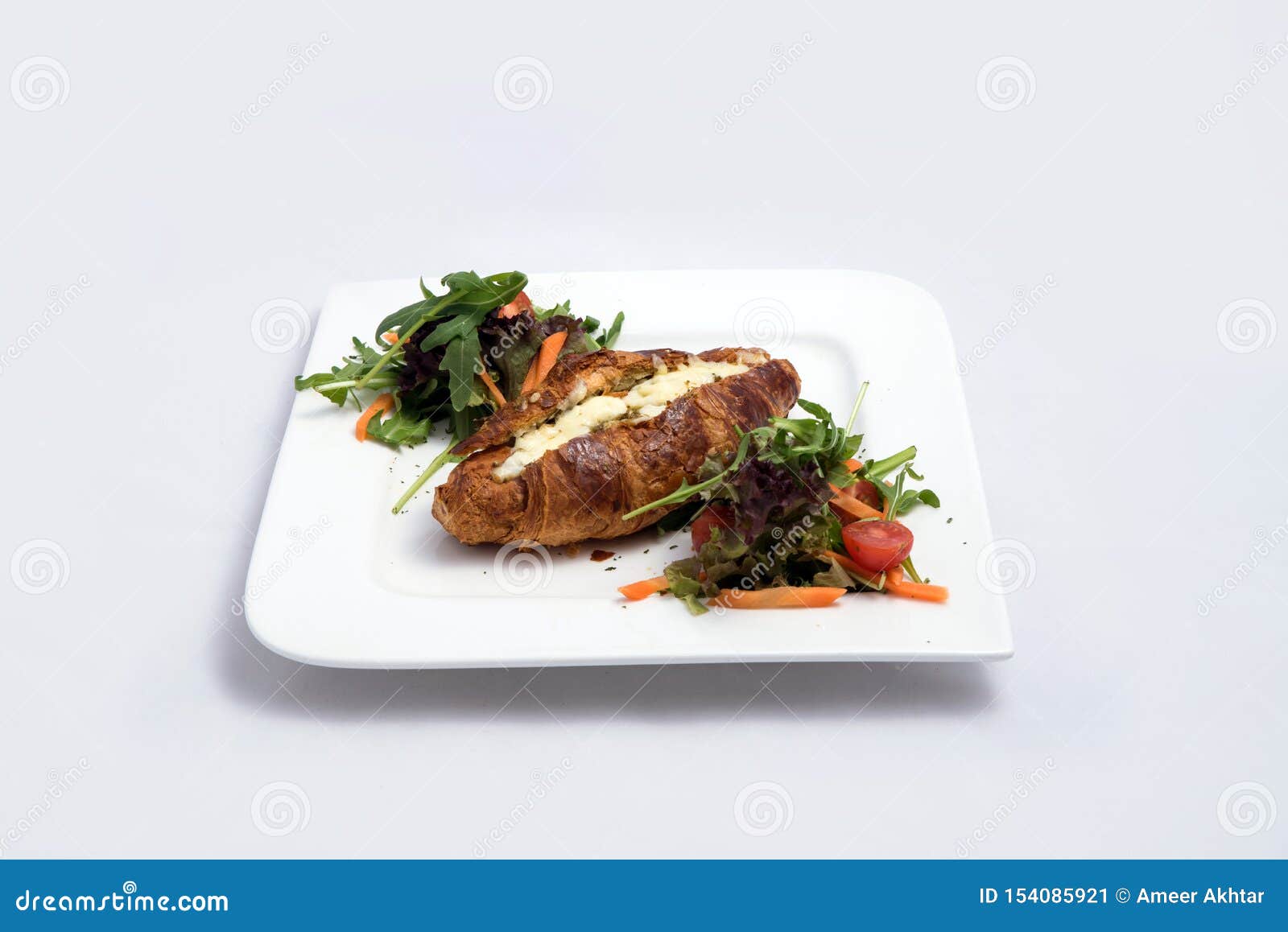 zoom-out hero shot of a breakfast platter with cheese and zaatar filled croissant with vegetables- carrot, tomato, lettuce