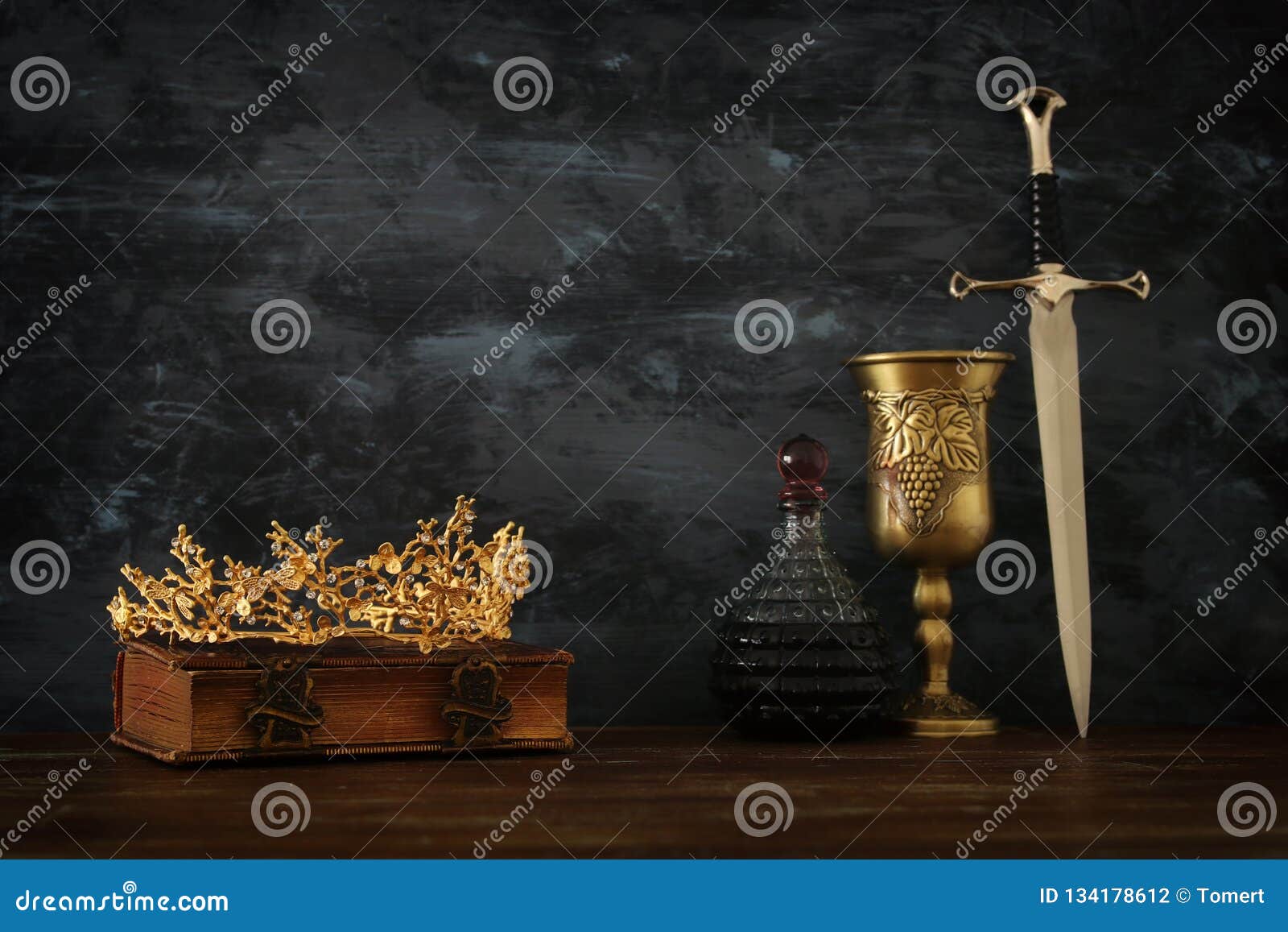 Low Key Image of Beautiful Queen/king Crown, Wine Cup and Sword