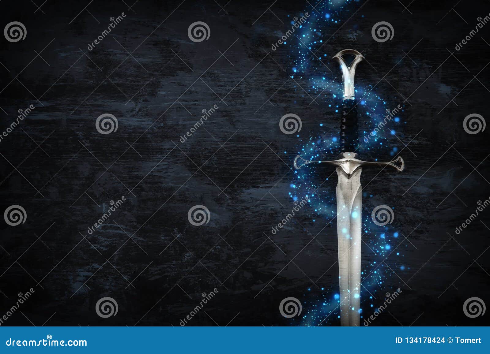 low key image of silver sword with magical lights. fantasy medieval period.