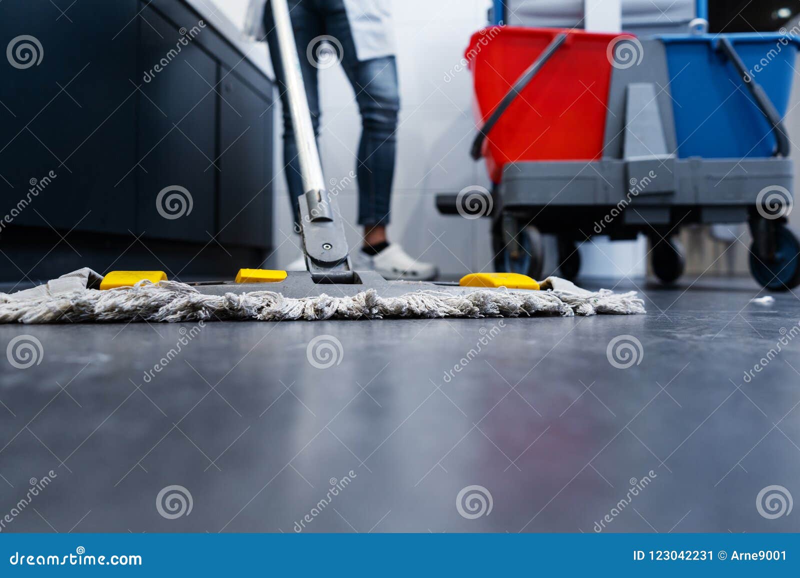 low shot of cleaning lady mopping the floor in restroom