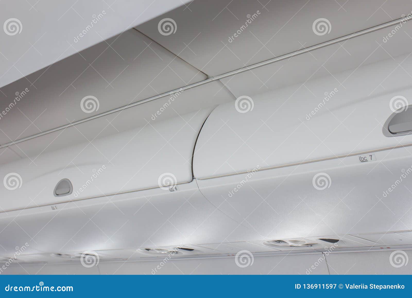 The Luggage Storage In An Airplane Above The Seats. The Flaps Of The