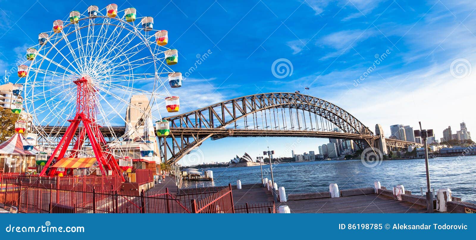 luna park wheel with harbour bridge arch in sydney, australia.