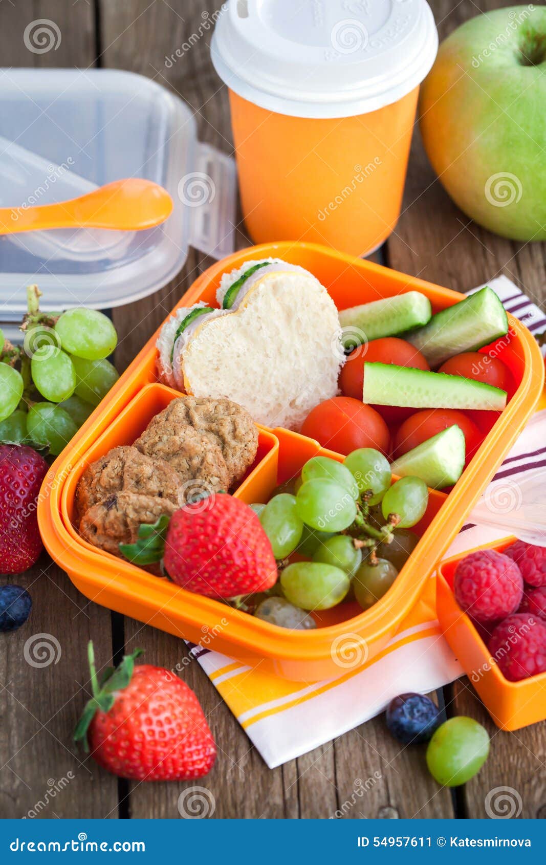 School lunch box with sandwich, vegetables, water, and fruits on table.  Healthy eating habits concept Stock Photo - Alamy