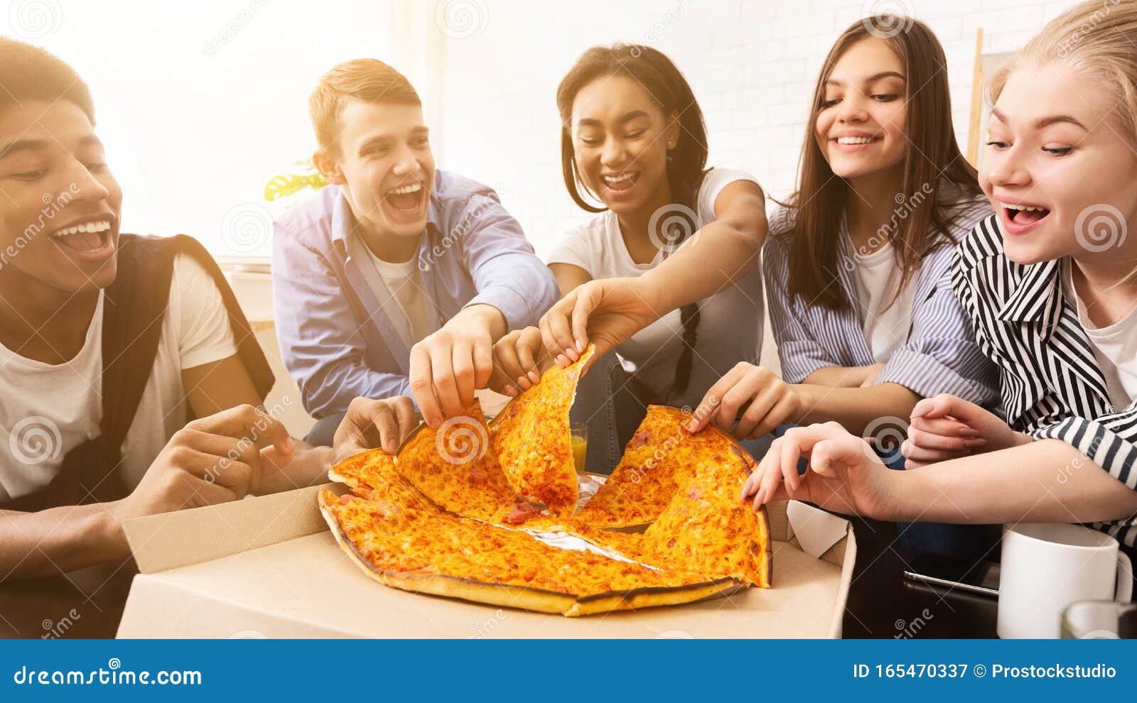 Happy african american friends eating pizza at home Stock Photo by  Prostock-studio