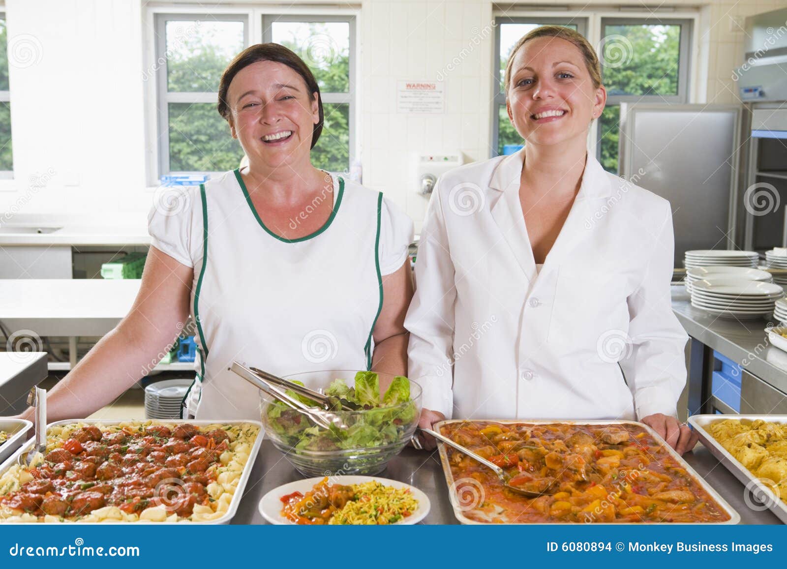 Lunchladies beside Trays of Food in a School Stock Photo Image of