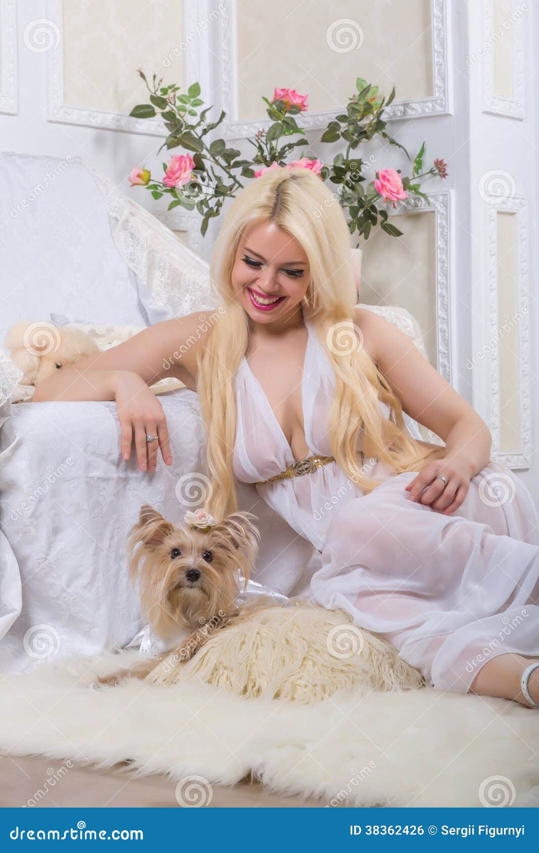 Luxurious blonde woman in a white dress with a dog pekingese in front of modern classical room