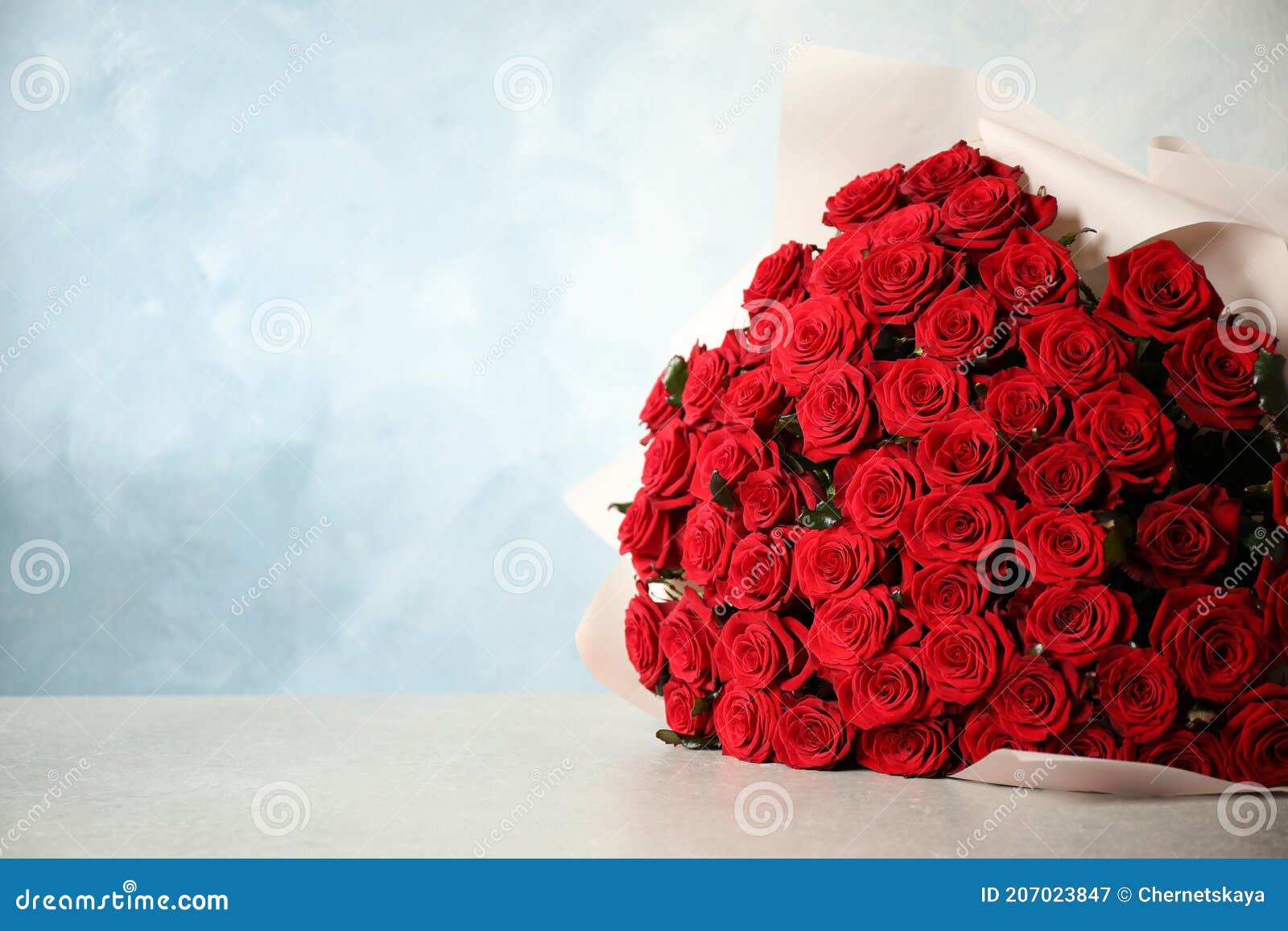 Luxury Bouquet of Fresh Red Roses on Light Table, Space for Text Stock