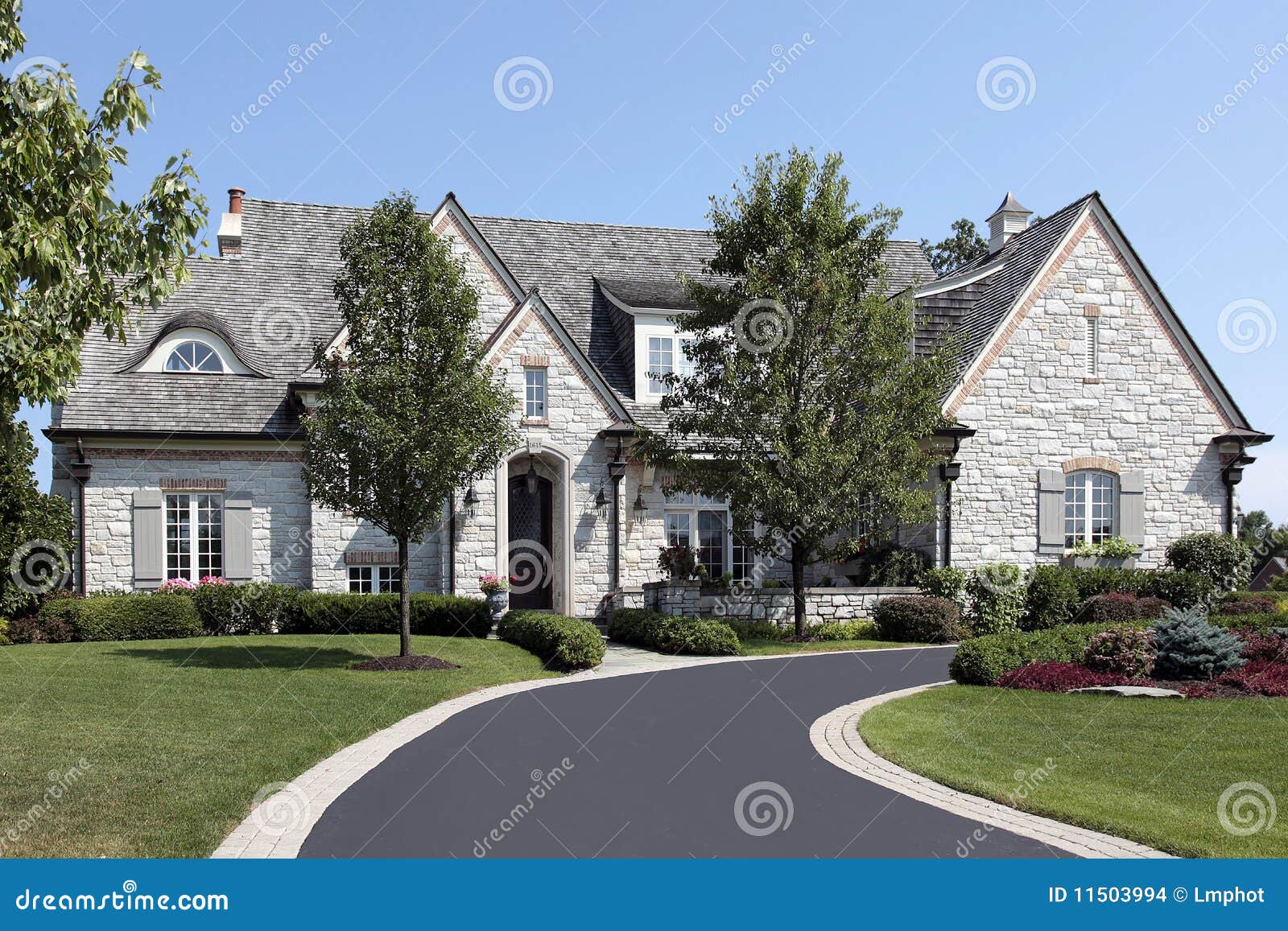 luxury stone home with circular driveway