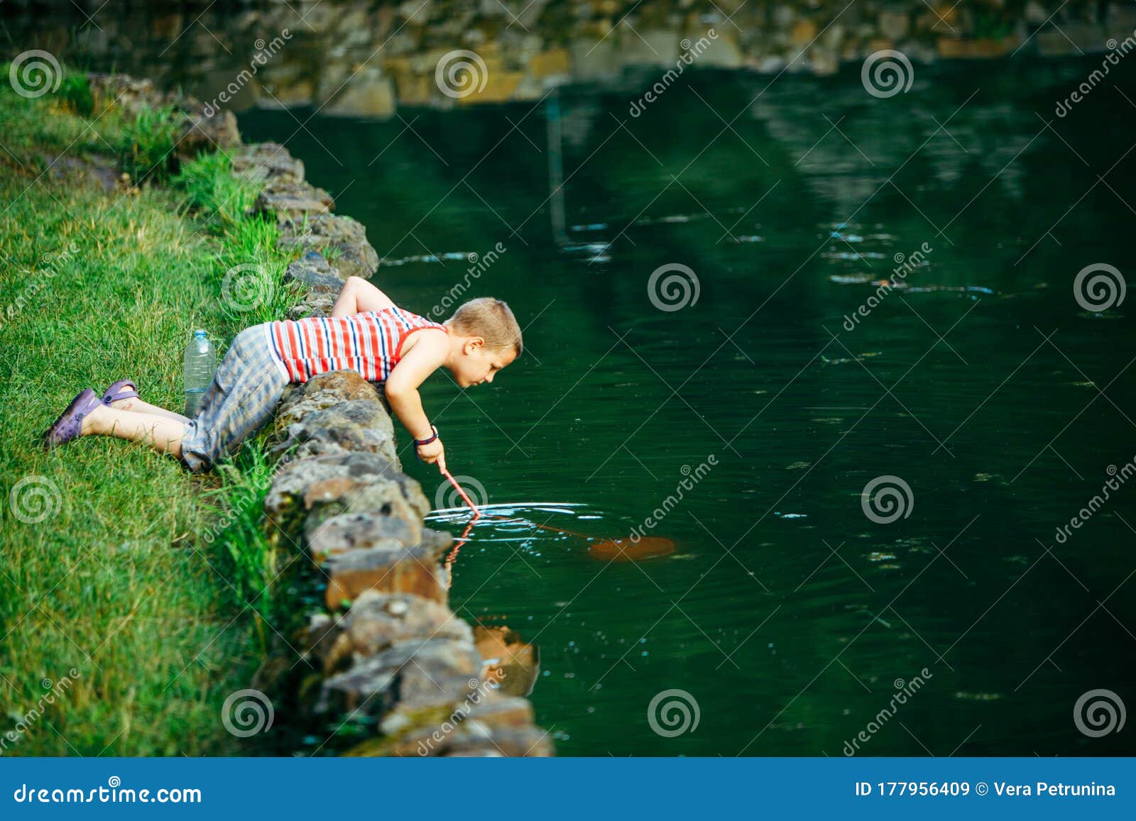 Lviv, Ukraine - June 23, 2019: Kid with Fish Net Looking Tadpole