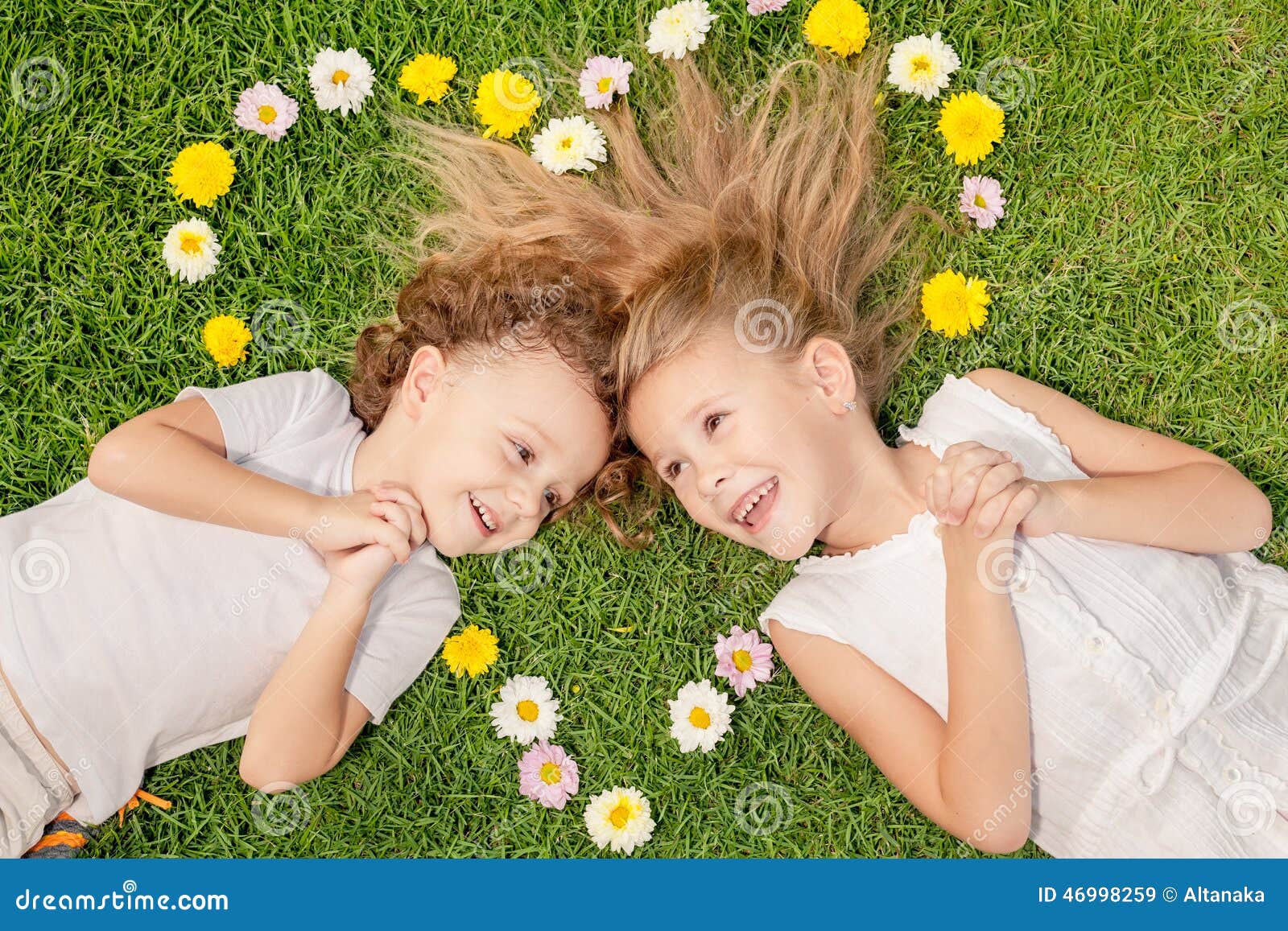 Lycklig pys och flicka som ligger på gräset på dagtiden Begrepp av en syskongruppför evigt Hjärta som läggas ut på gräset av färgerna, begreppet av valentin dag