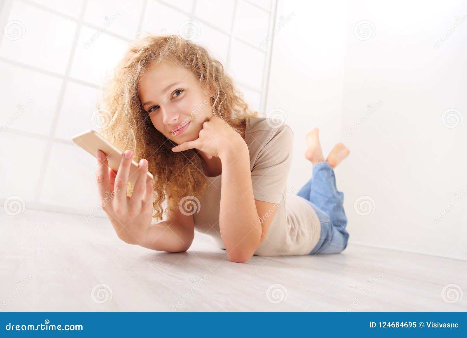 Lying Young Woman On Floor Talking On Cellphone With Long Hair