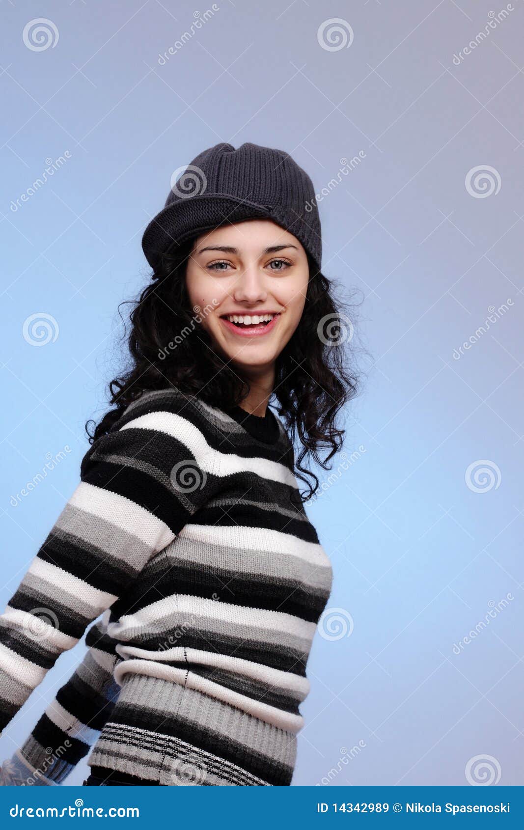 Lächeln des jungen Mädchens. Portrait eines schönen jungen lächelnden Mädchens, auf blauem Hintergrund