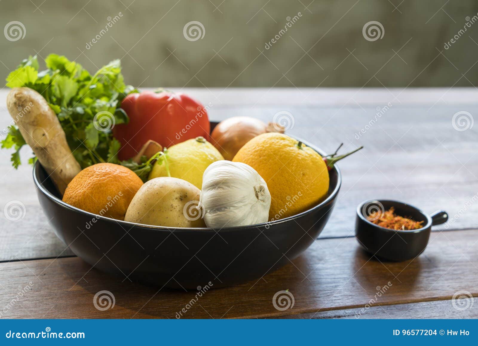Légumes frais dans un plateau, courgettes, oignon, orange, citron, à. Un plateau des légumes frais sur une table en bois, courgettes, oignon, orange, citron, tomate, pomme de terre