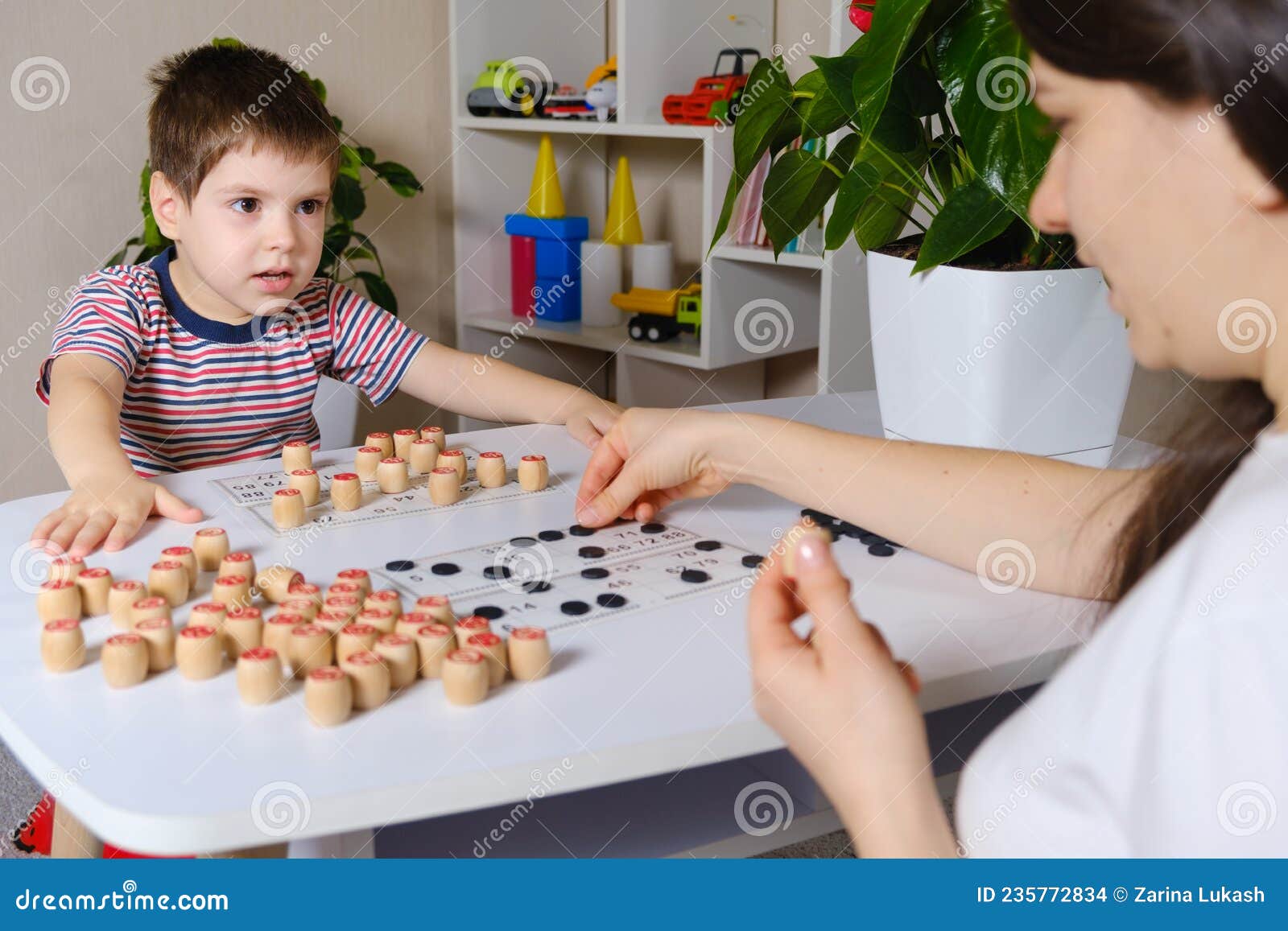 Um menino de 4 anos joga números de estudos de loto usando um jogo