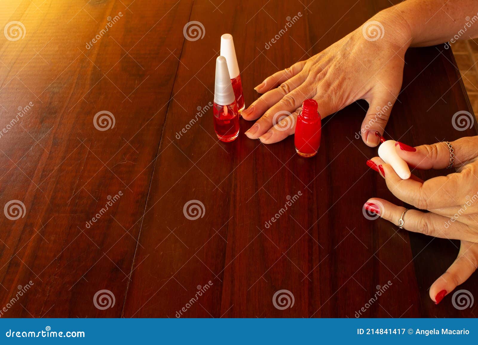 Mãos femininas bem cuidadas. senhora pintando, lustrando unhas. esmalte e  lima de unha.