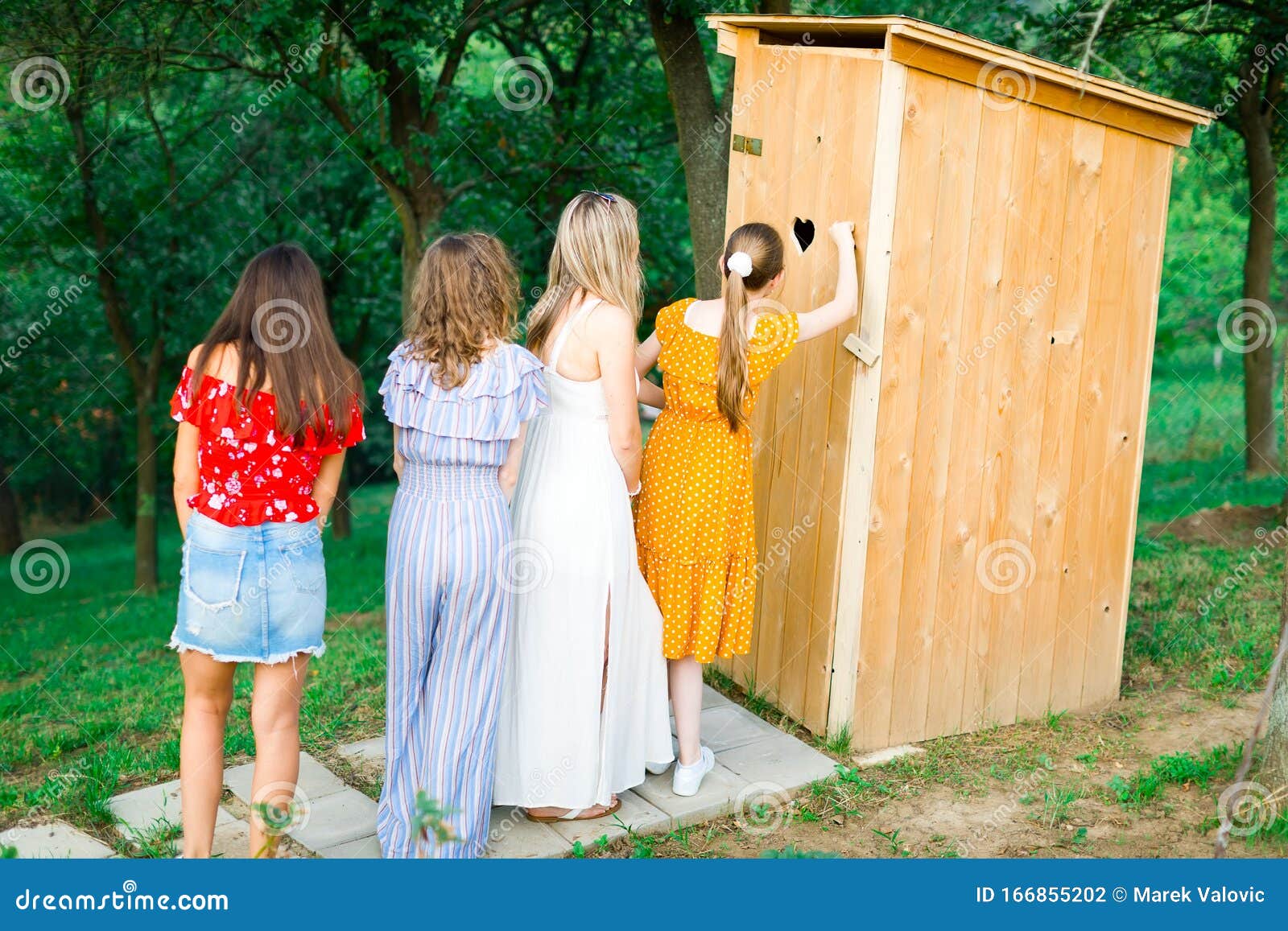 Madchen Und Frauen Warten Auf Eine Toilette Aus Holz Im Freien Stockfoto Bild Von Fahrwerkbein Mode 166855202