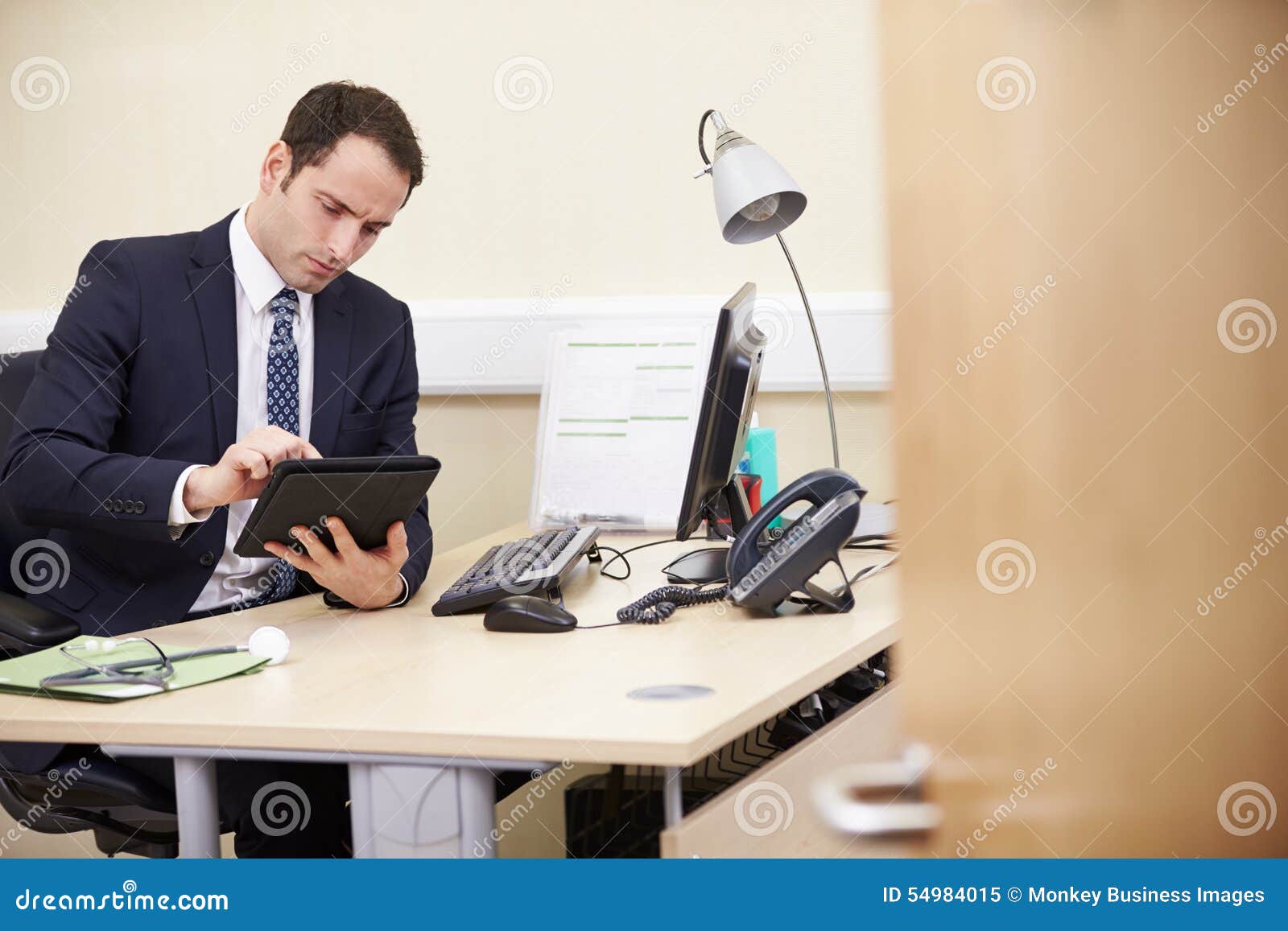 Männlicher Berater Using Digital Tablet am Schreibtisch Im Büro Stockbild -  Bild von horizontal, leute: 54984015