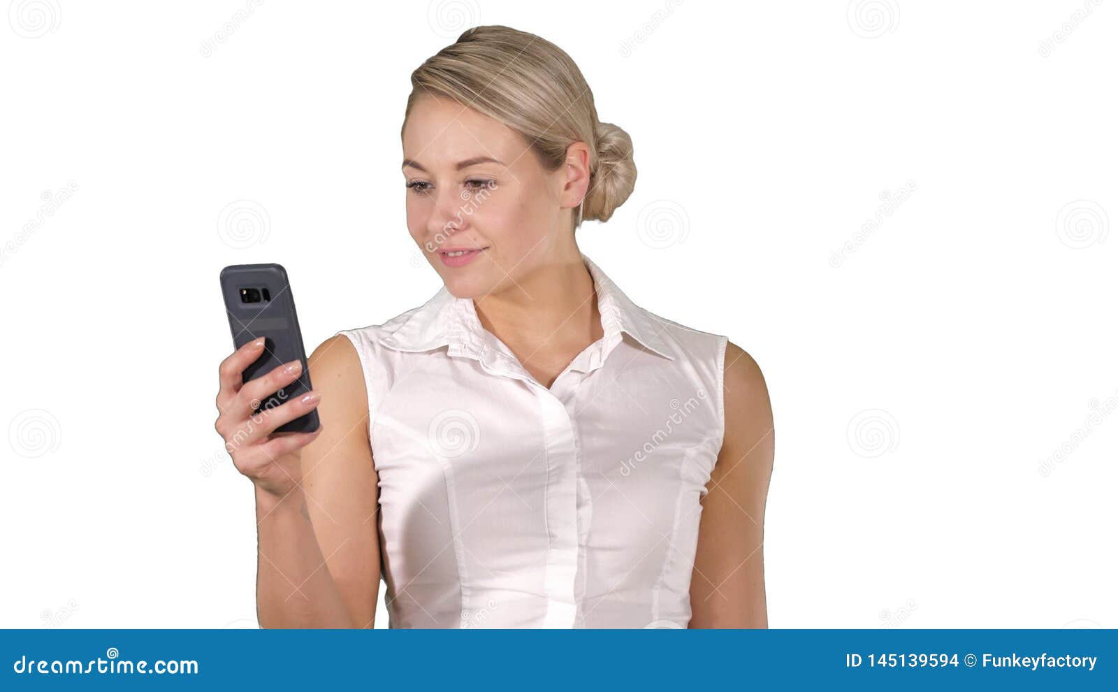 Medium shot. Young girl reading from mobile phone screen on white background. Professional shot in 4K resolution. 005. You can use it e.g. in your commercial video, business, presentation, broadcast