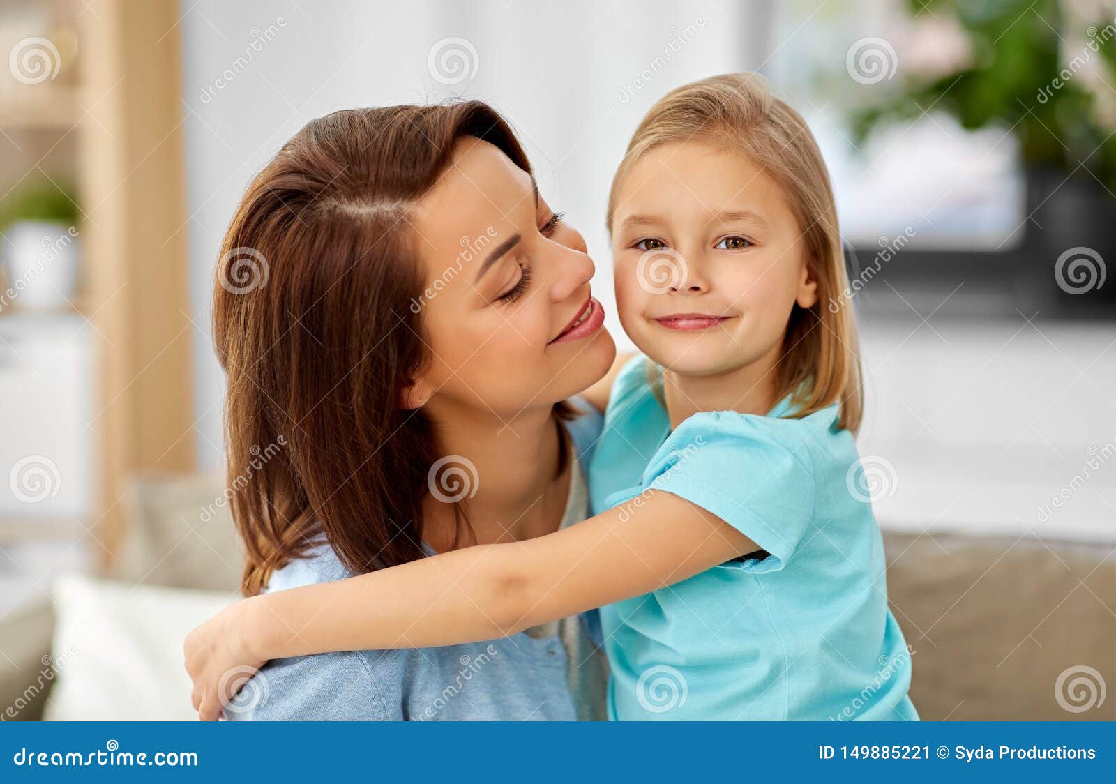 Little Daughter Hugging Her Mother On Sofa At Home Obraz Stock Obraz